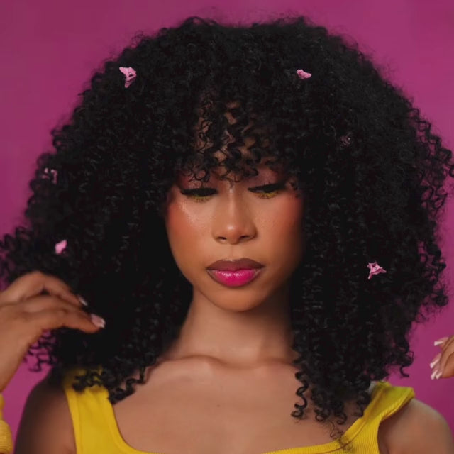 montage clips of a woman posing in the afro-curly diva wig